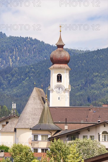 Church with high bell tower in a traditional alpine village, surrounded by mountains and many houses, Achernsee, Austria, Germany, Europe