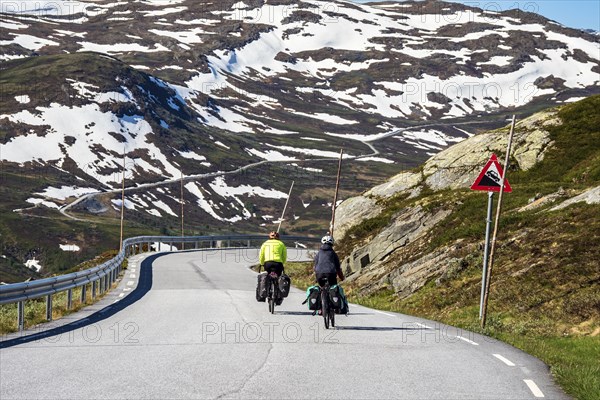 Cyclists on mountain crossing Sognefjellsvegen, mountain pass over the Sognefjellet, touristic road, at Nedre Oscarshaug viewpoint, Norway, Europe