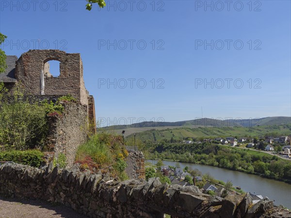 Old wall near a river with a view of the village and hills, Saarburg, Germany, Europe