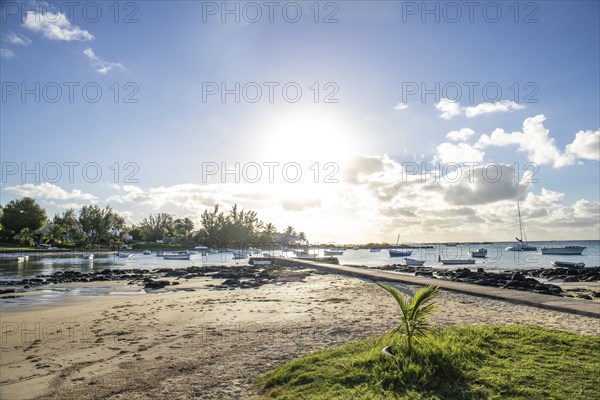 Landscape with a view over a small harbour with fishing boats. Tropical landscape with a view of the sunset at Cape Malheureux, Mauritius, Africa