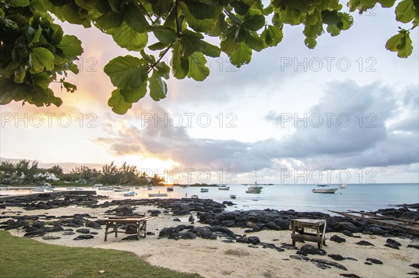 Landscape with a view over a small harbour with fishing boats. Tropical landscape with a view of the sunset at Cape Malheureux, Mauritius, Africa