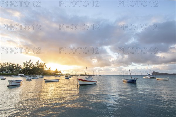 Landscape with a view over a small harbour with fishing boats. Tropical landscape with a view of the sunset at Cape Malheureux, Mauritius, Africa