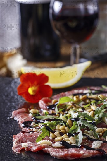 Fresh carpaccio with rocket on slate