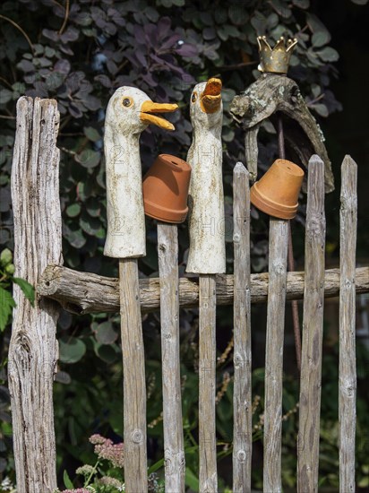 Rustic wooden fence with duck statues and upturned clay pots as decoration, SChermbeck North Rhine-Westphalia, Germany, Europe