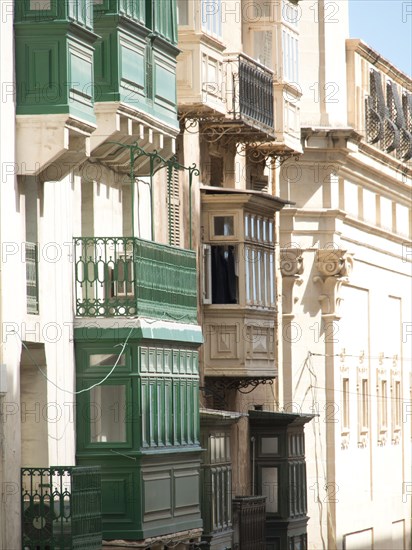 Several houses with existing wooden balconies painted in green and beige, valetta, mediterranean sea, malta
