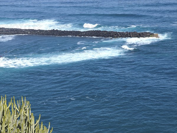 Close-up of a coastal area with strong waves and blue sea water, Puerto de la cruz, tenerife, spain