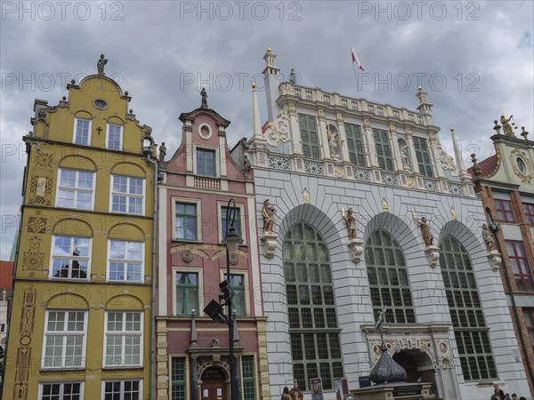 View of historical buildings with decorated facades and sculptures under a cloudy sky, Gdansk, Poland, Europe