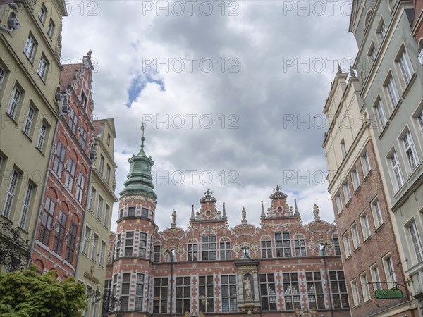Historic buildings with an ornate church tower and a cloudy sky, Gdansk, Poland, Europe
