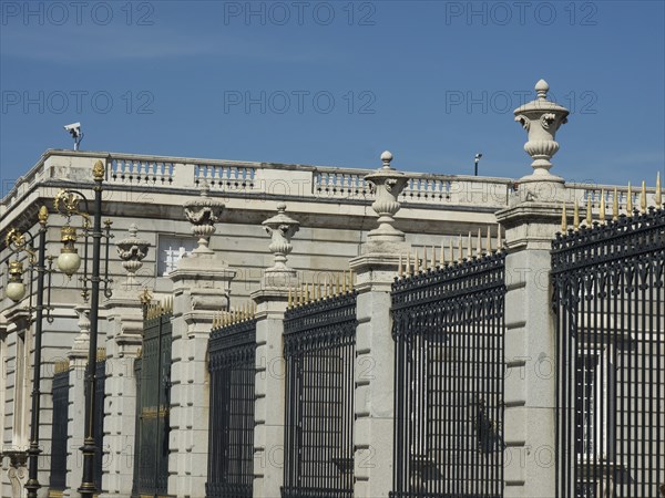 A historic wall with a pointed fence and golden decorations in beautiful weather, Madrid, Spain, Europe