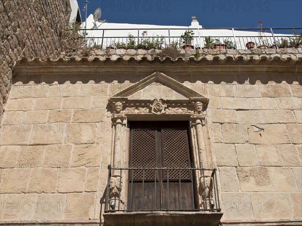 Historic building with stone façade and balcony in rustic architecture, ibiza, mediterranean sea, spain