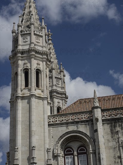 Gothic architecture of a cathedral with striking towers in front of a partly cloudy sky, Lisbon, portugal