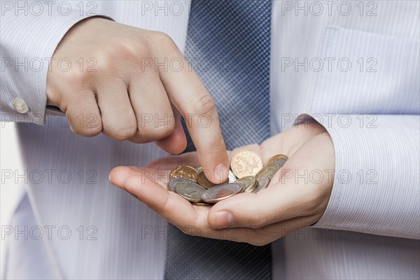 Business risks and finance issues concept, businessman hand holding coin savings counting money profit or losses
