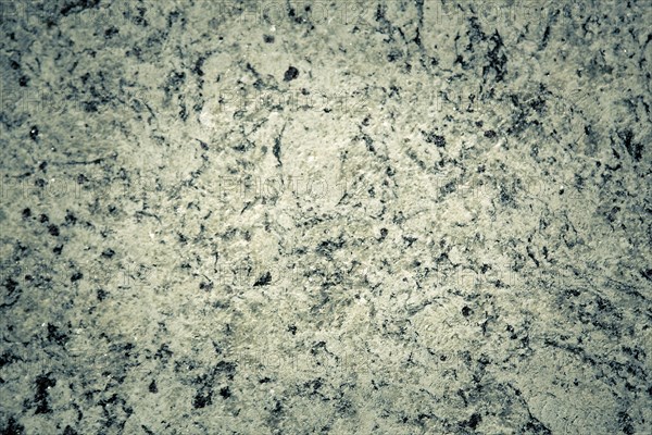 Rough granite texture with gray and black spots, displaying a natural rugged appearance, background image