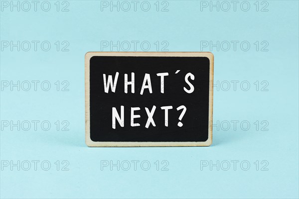 The phrase what´s next is standing on a chalkboard, having new goals and strategies, making plans for future