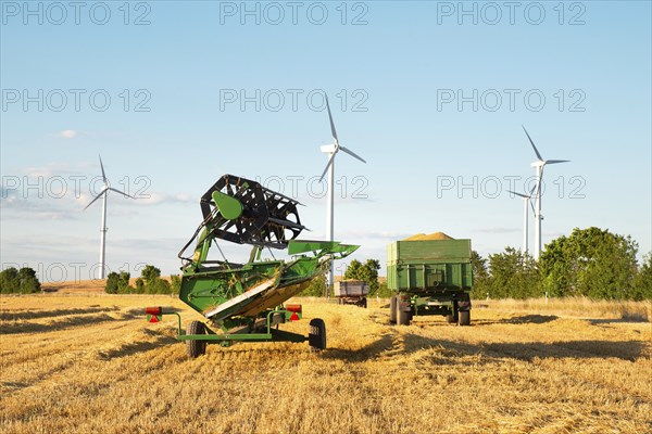 Harvester in a field of cultivated barley in Germany, harvest in the summer, agriculture for food, farmland on the countryside