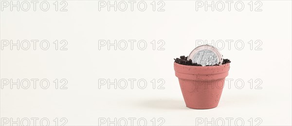 One Euro coin in small flowerpot, money growing, financial planning, profitable investment, hope concept