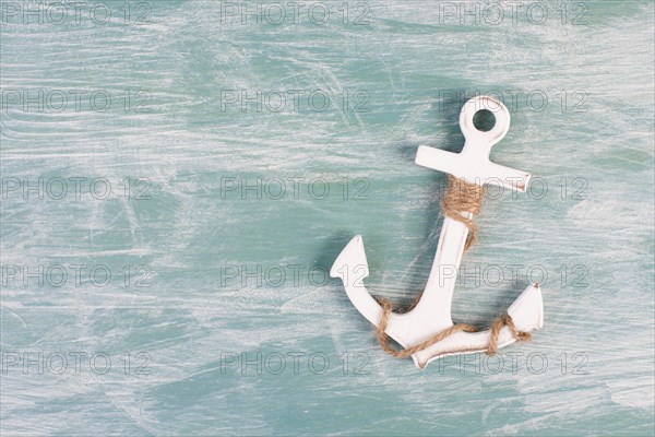 White anchor on a blue textured background, maritime sea life, sailing trip, summer vacation, tourism concept, harbor