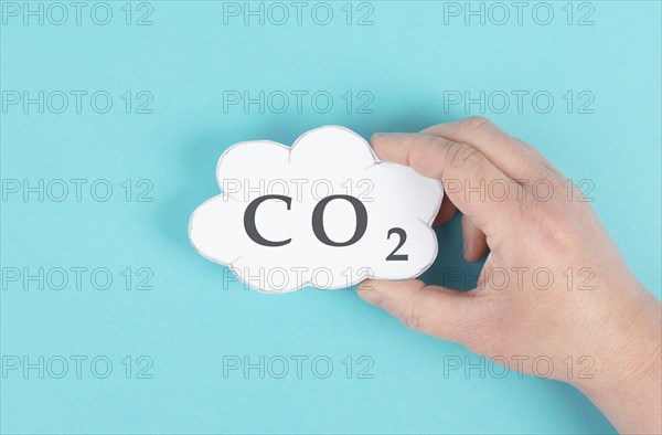 Hand holds cloud with the word CO 2, carbon dioxide emission, environmental issue, air pollution
