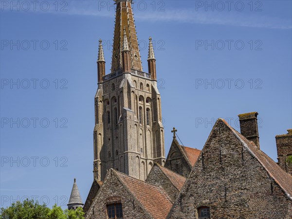 Detailed gothic church and church tower, historic brick buildings in the foreground, Bruges, Flanders, Belgium, Europe