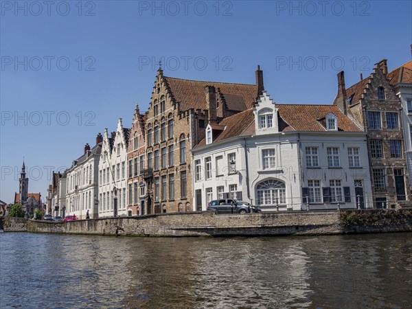 Row of historic buildings along a canal with detailed architecture and clear sky, Bruges, Flanders, Belgium, Europe