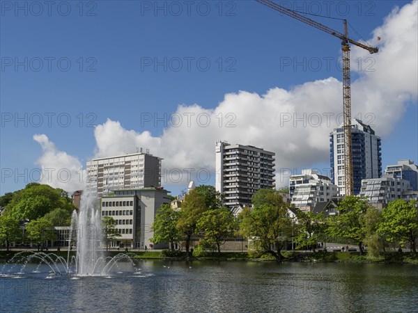 City skyline with a lake and fountain, surrounded by modern buildings and a crane, Stavanger, Norway, Scandinavia, Europe
