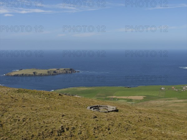 View of an island in the sea, surrounded by green hills, lerwick, shetlands, scotland, Great Britain