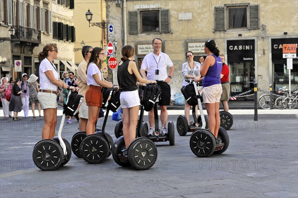 Florence, Tuscany, Italy, Europe, A group of people on Segways on a city tour on a sunny day, Europe