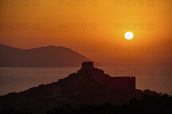 Castle ruins in silhouette against a dramatic sunset over the sea and mountains, Kritinia Castle, St John's Castle, Kritinia, Rhodes, Dodecanese, Greek Islands, Greece, Europe