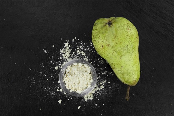 Portion of fresh made Pear powder on a slate slab (selective focus)