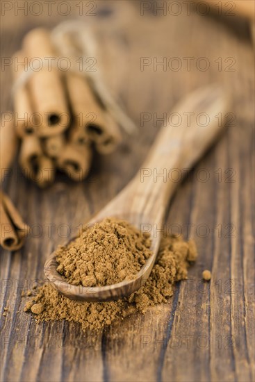 Cinnamon Powder as high detailed close-up shot on a vintage wooden table (selective focus)