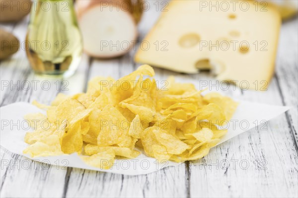 Cheese and Onion Potato Chips on a vintage background as detailed close-up shot (selective focus)