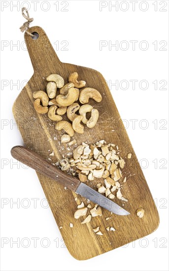 Portion of chopped Cashew nuts isolated on pure white background (detailed close-up shot)