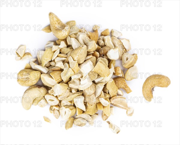 Portion of chopped Cashew nuts isolated on pure white background (detailed close-up shot)