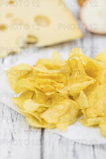 Cheese and Onion Potato Chips on rustic wooden background (close-up shot)