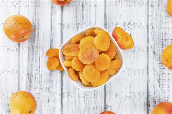 Dried Food (Apricots) on an old wooden table as detailed close-up shot (selective focus)