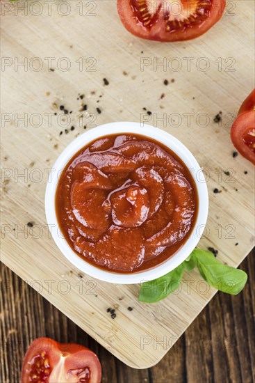 Fresh made Ketchup on a vintage background (close-up shot)