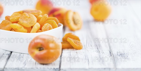 Dried Food (Apricots) on an old wooden table as detailed close-up shot (selective focus)