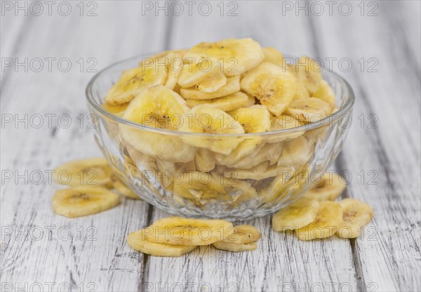 Fresh made Dried Banana Chips on an old and rustic wooden table, selective focus, close-up shot