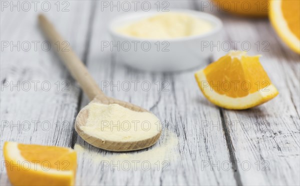 An old wooden table with orange fruit powder (selective focus)