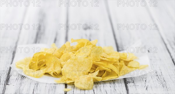 Cheese and Onion Potato Chips on a vintage background as detailed close-up shot (selective focus)