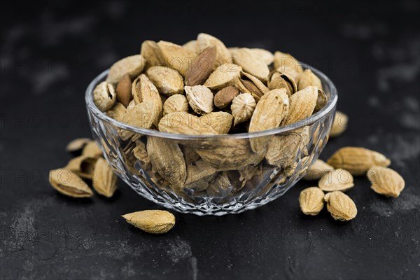 Dark slate slab with roasted and salted Almonds (in the shell)