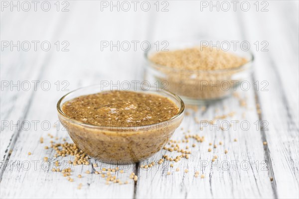Mustard (sweet) on rustic wooden background (close-up shot)