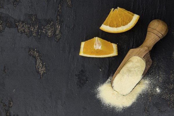 Orange fruit powder on a slate slab (selective focus, close-uo shot)