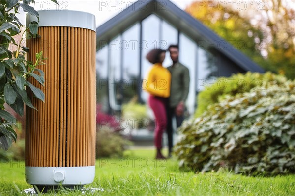 Modern air purifier in a garden, blurred view of a couple in the background, AI generated, AI generated