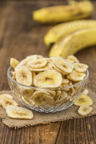 Dried Banana Chips on a vintage background as detailed close-up shot, selective focus