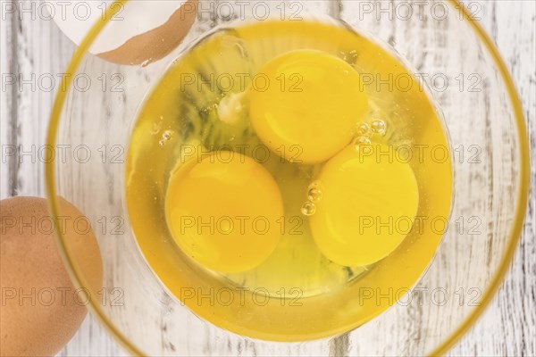 Some Raw Eggs on a vintage wooden table (selective focus, close-up shot)