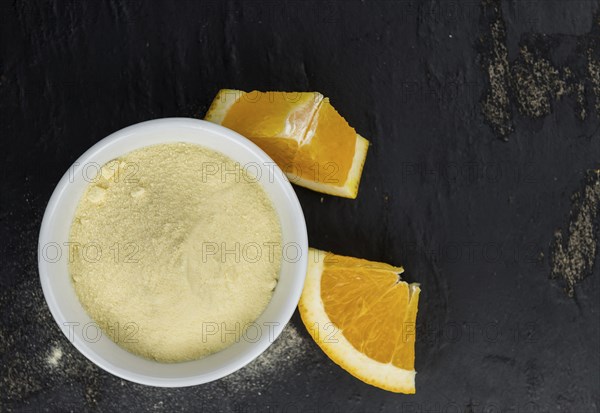 Orange fruit powder on a slate slab (selective focus, close-uo shot)