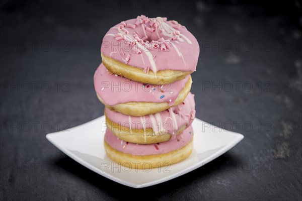Portion of pink glazed Donuts (detailed close-up shot)