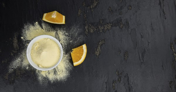Orange fruit powder on a slate slab (selective focus, close-uo shot)