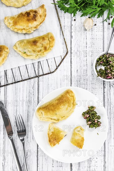 Portion of healthy Empanadas on an old wooden table (selective focus, close-up shot)